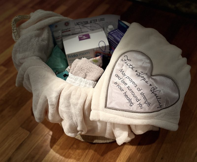 An open Basket of Healing: a cream rope basket lined with a soft blanket and filled with postpartum recovery supplies